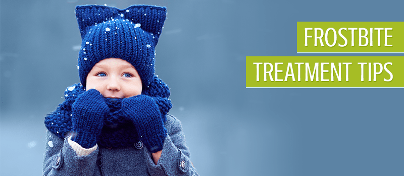 Child wearing a knitted blue hat, mittens, and scarf on a snowy day
