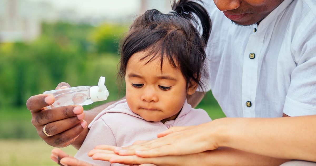 little girl learning hand sanitizer safety