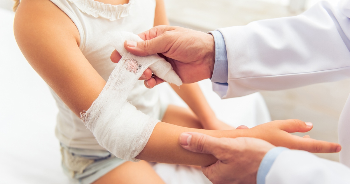 child getting wrapped by doctor due to sprain or break